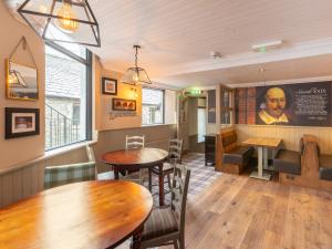 a restaurant with tables and chairs in a room at Shakespeare Inn in Kendal