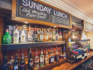 un bar lleno de muchas botellas de alcohol en Shakespeare Inn, en Kendal