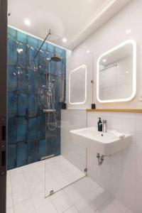 ブダペストにあるCozy&Stylish at the Eastern Railway St. w Balconyのシャワー、洗面台、鏡を備えたバスルーム +17枚の写真