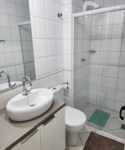 a bathroom with a sink and a toilet and a shower at Apartamento pe na areia e com vista linda in Florianópolis