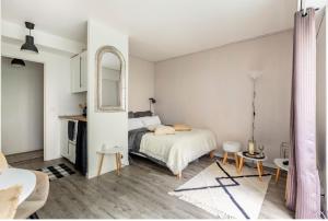 una camera bianca con letto e specchio di Appartement Cosy Paris centre a Parigi