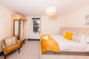 een slaapkamer met een bed en een stoel bij Warm&Welcoming City Centre Apartments by Meadows 7 in Edinburgh