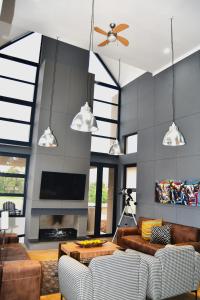 a living room with two couches and a tv at VAAL DE GRACE golf estate The SHACK in Parys