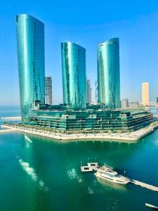 a city with tall buildings and boats in the water at Harbour View Condo - Seaview اطلالة بحرية in Manama