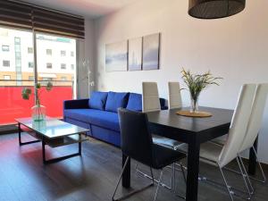 a living room with a table and a blue couch at Barcelona Beach Breeze in Barcelona