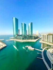 a view of a city with tall buildings in the water at Harbour View Condo - Seaview اطلالة بحرية in Manama