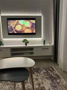 a living room with a tv on a wall at SC Tirana Centre Apartment in Tirana