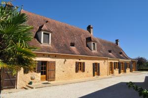 a large brick building with windows and a roof at Gîte pour 4 personnes - Dordogne in Bressac