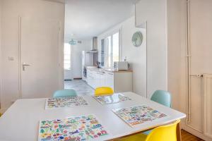 una cucina con tavolo bianco e sedie gialle di L'Oasis Urbaine à Angoulême - Pro ou Groupe ad Angoulême