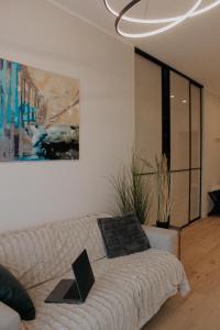 ein Wohnzimmer mit einem Sofa und einem Gemälde in der Unterkunft Albatross Club House 9 in Ķesterciems