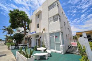 a white building with a bench in front of it at Treehouse Hotel in Miami