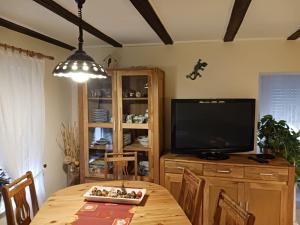 a dining room with a table and a television at Ferienwohnung Lücking im Westerwald in Flammersfeld