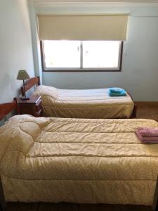 two beds in a room with a window at Samaraña depto Jujuy in San Salvador de Jujuy