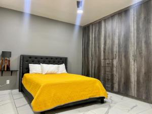 1 dormitorio con 1 cama con manta amarilla en DEPARTAMENTOS ARTICULO 123 - departamento #2, en Tijuana