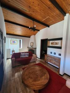 uma sala de estar com um sofá e uma mesa em Chalés Juliana Casa 1 em Monte Verde