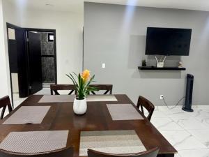 a dining room with a table and chairs and a television at DEPARTAMENTOS ARTICULO 123 - departamento #2 in Tijuana