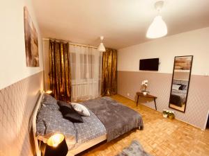 sypialnia z łóżkiem i telewizorem w obiekcie ClickTheFlat Wokalna Apart Rooms w Warszawie