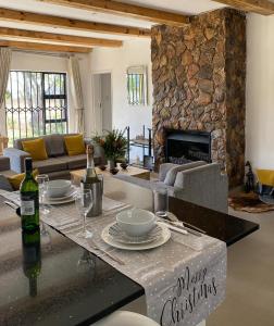 a living room with a table and a fireplace at Msasa Views Cottage in Juliasdale
