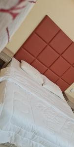a bed with a red headboard in a room at شاليهات الدرب منتجع ليله in Qarār
