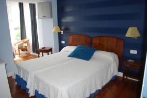 1 dormitorio azul con 1 cama con pared azul en Casa de marinos UribeKosta, en Plentzia
