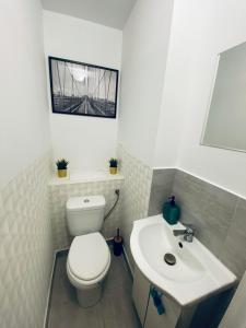 ein Bad mit einem WC und einem Waschbecken in der Unterkunft ClickTheFlat Wokalna Apart Rooms in Warschau