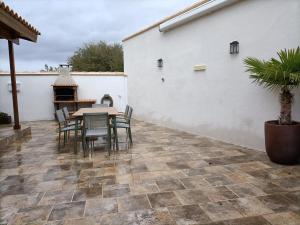 a patio with a table and chairs and a fireplace at La Dehesa2 de Toledo in Cobisa