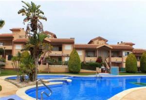 a large swimming pool in front of a building at Adosado con piscina y terraza a 700m de la playa in Gran Alacant