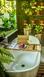 una bañera en un jardín con plantas en KAÑIK APART HOTEL, en Puerto Viejo