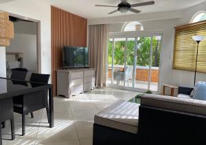 ein Wohnzimmer mit einem Sofa und einem TV in der Unterkunft Bahia Residence Cabarete in Cabarete