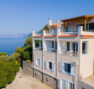 a white building with a view of the water at The Life Suites in Limnionas