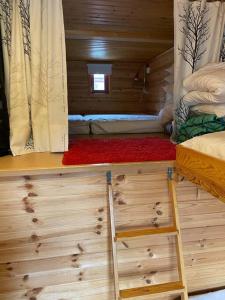 a room with two beds and a ladder in a cabin at Välplanerad ski-in/out stuga med bastu in Gällivare