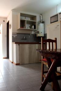 a kitchen with a wooden table and a refrigerator at Rayentray in El Bolsón