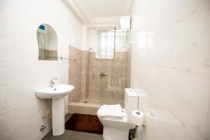 a bathroom with a toilet and a sink and a shower at Executive Two Bedroom Apartment in Accra in Accra +36 photos