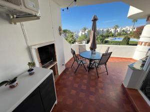 a living room with a table and chairs and a fireplace at Jardines de Calahonda in Mijas Costa