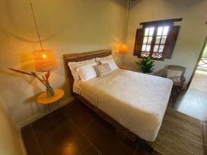 a bedroom with a bed and a lamp and a window at Mentto Hotel in Guaduas
