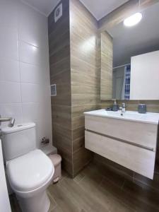 ein Badezimmer mit einem WC, einem Waschbecken und einem Spiegel in der Unterkunft Cómodo Dpto con Piscina a pasos de Mall La Portada in Antofagasta
