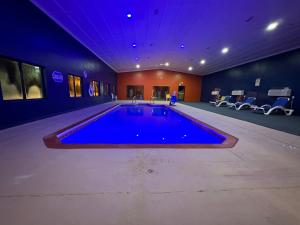 a large swimming pool in a room with a purple ceiling at Super 8 by Wyndham Tucumcari in Tucumcari