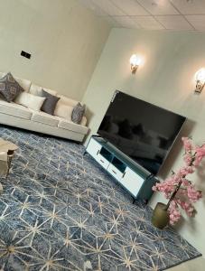 a living room with a large flat screen tv at Relaxing Alula in Al-ʿUla