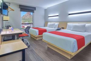 een hotelkamer met 2 bedden en een bureau bij City Express by Marriott Guaymas in Guaymas