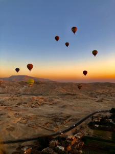um grupo de balões de ar quente voando no céu em House of Dreams apartments Luxor em Luxor