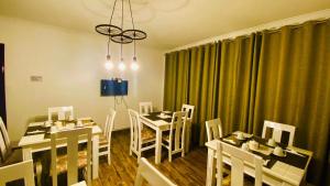 恩德培的住宿－Nimaro Courts，用餐室配有白色的桌子和白色的椅子