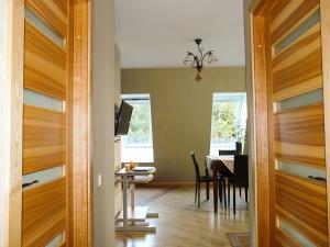 a dining room with a table and a dining room door at Gaja in Nida +3 photos