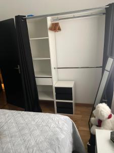 um quarto com uma cama e um armário com um urso de peluche em Appartement - Chic et Cosy à 30 minutes de Paris et 25 minutes de Disney em Ozoir-la-Ferrière