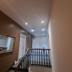 un couloir avec un escalier avec un miroir et un miroir dans l'établissement The Beath Inn, à Cowdenbeath