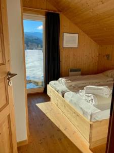 um quarto com uma cama e uma grande janela em Chalet Bellevue Murau em Murau