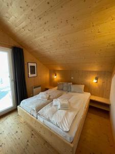 a large bed in a room with a wooden ceiling at Chalet Bellevue Murau in Murau
