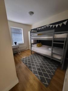 1 dormitorio con 2 literas y alfombra en Harborne House en Birmingham
