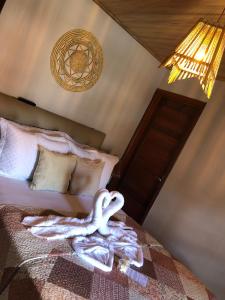 Un cisne hecho de toallas en una cama en Casa Milagres do Porto - Suítes, en São Miguel dos Milagres