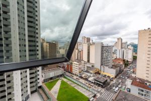 a view of a city from a window of a building at Bristtol Metropolitan Flat in Curitiba