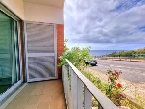 a building with a door on the side of a road at Junto ao Mar - Apartamento T1 in Santa Cruz